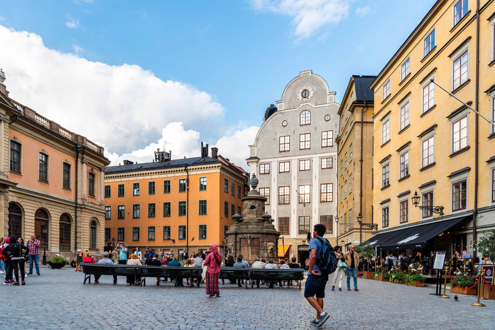 Plaza de Estocolmo con fachadas de colores, una fuente y turistas