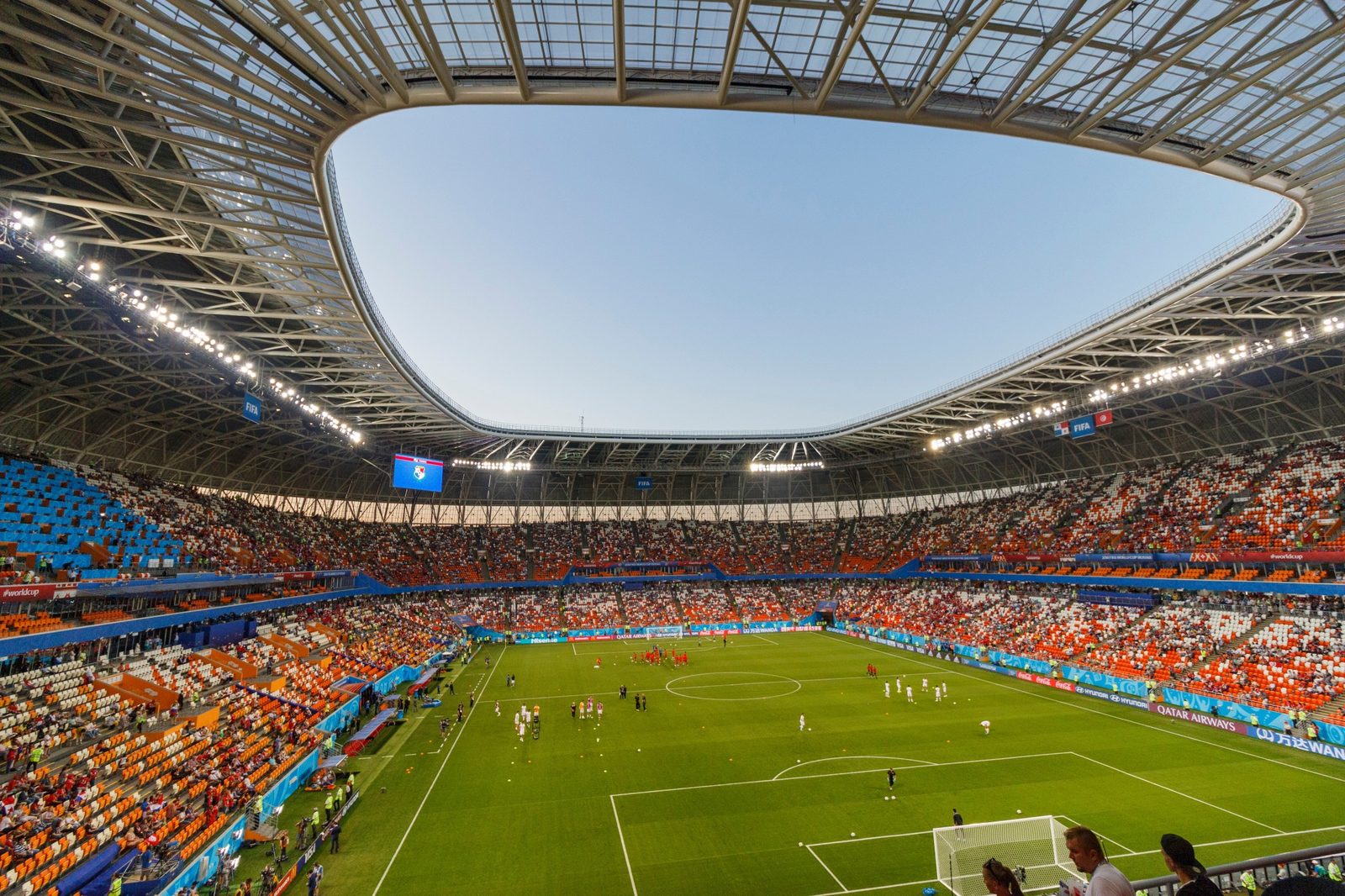 Estadio de futbol lleno visto desde las gradas superiores en un día soleado