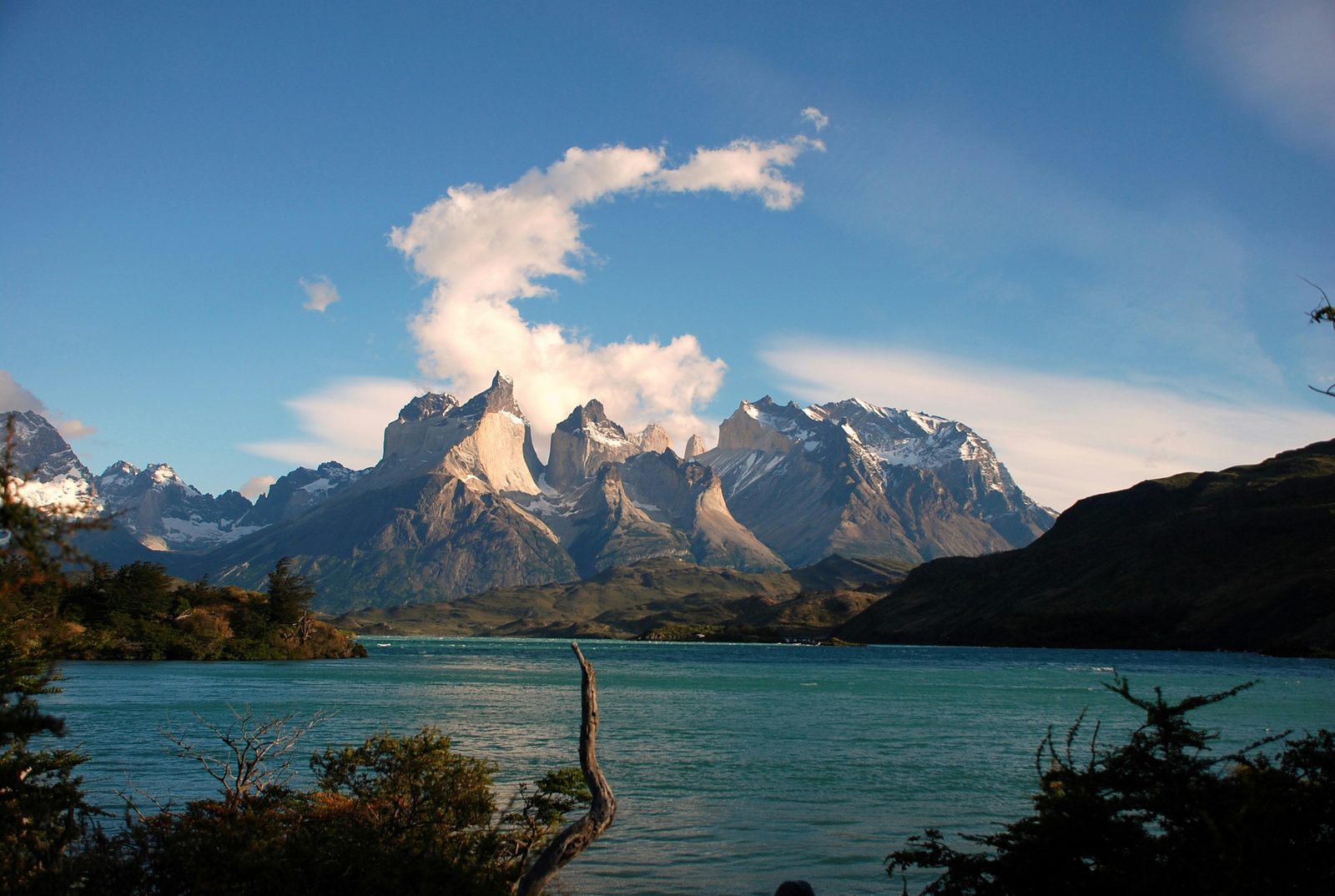 Lago rodeado de montañas nevadas de picos afilados en la Patagonia