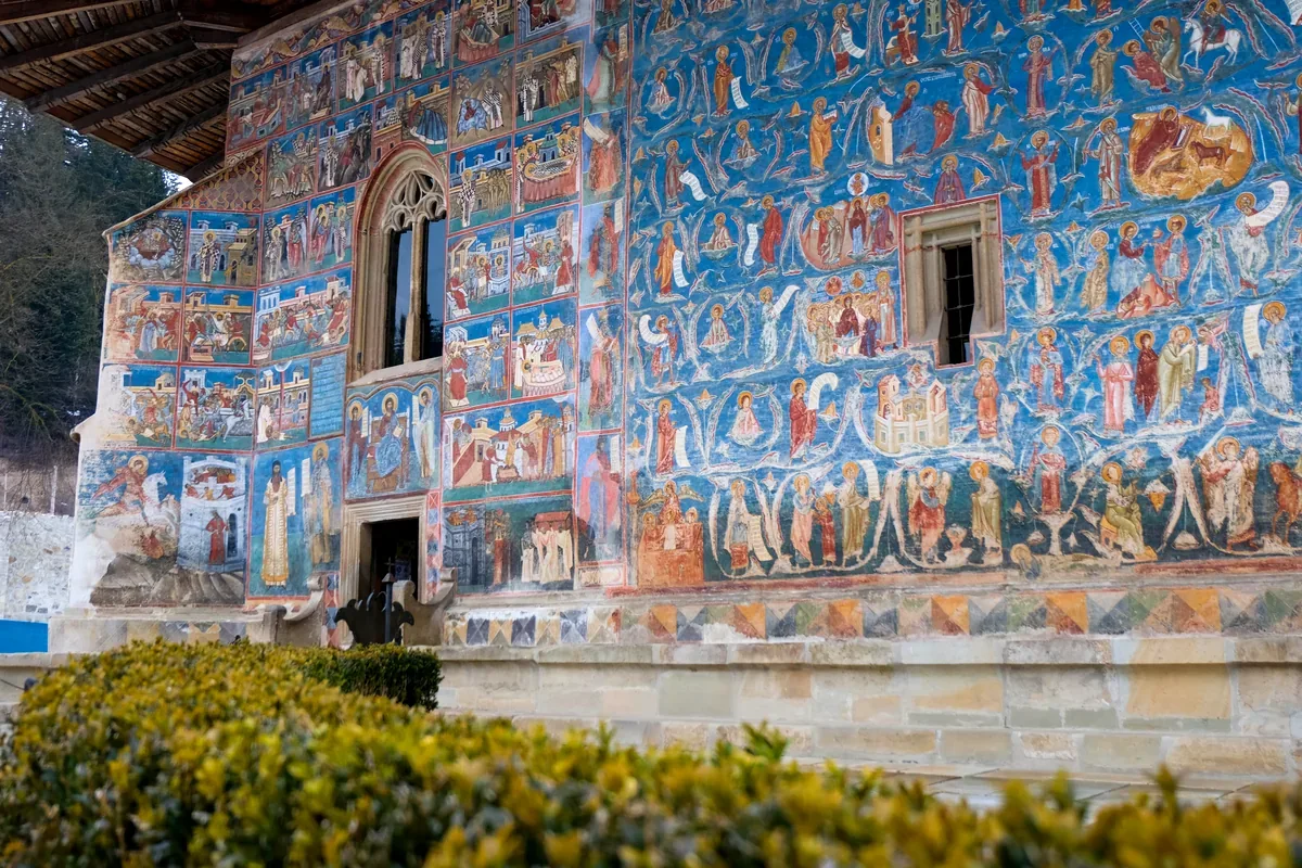 Muro de un monasterio pintado con frescos de escenas religiosas