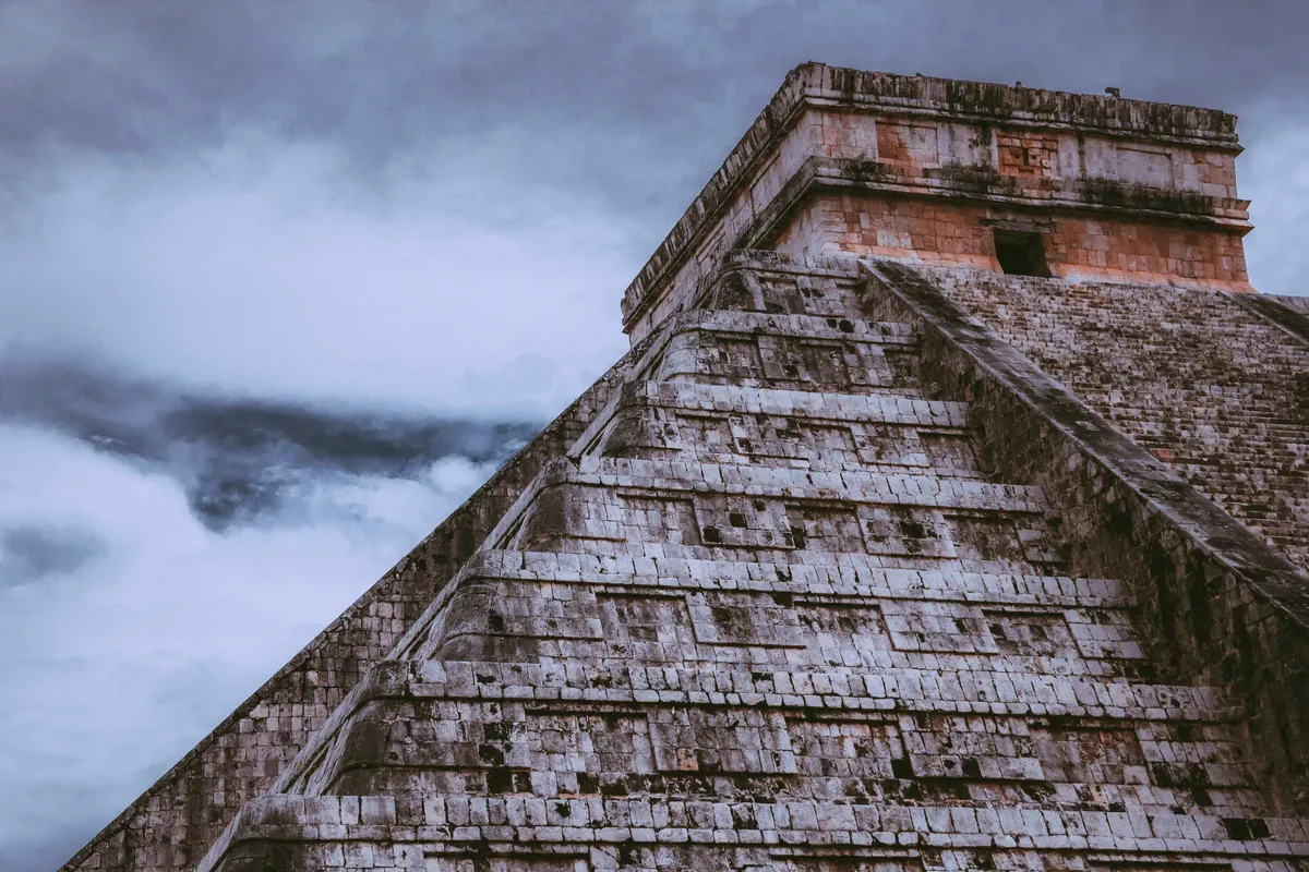 Escalinata de El Castillo de Chichén Itzá bajo un cielo gris