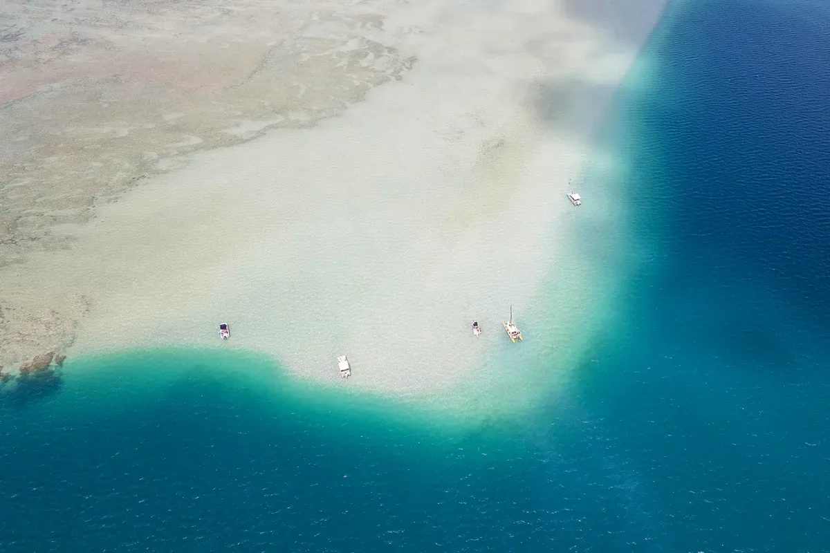 Banco de arena blanca rodeado de mar turquesa visto desde el aire