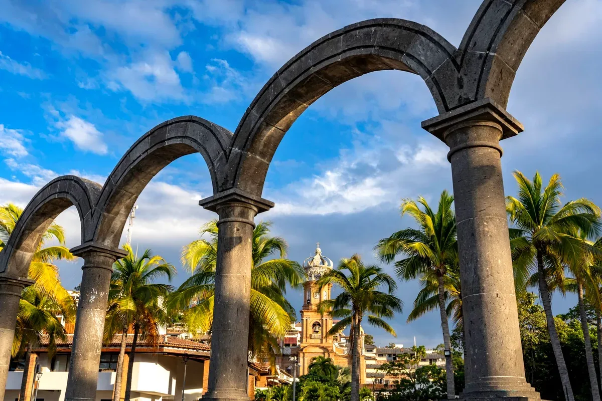 Los arcos del malecón de Puerto Vallarta con la torre de la parroquia de Guadalupe al fondo