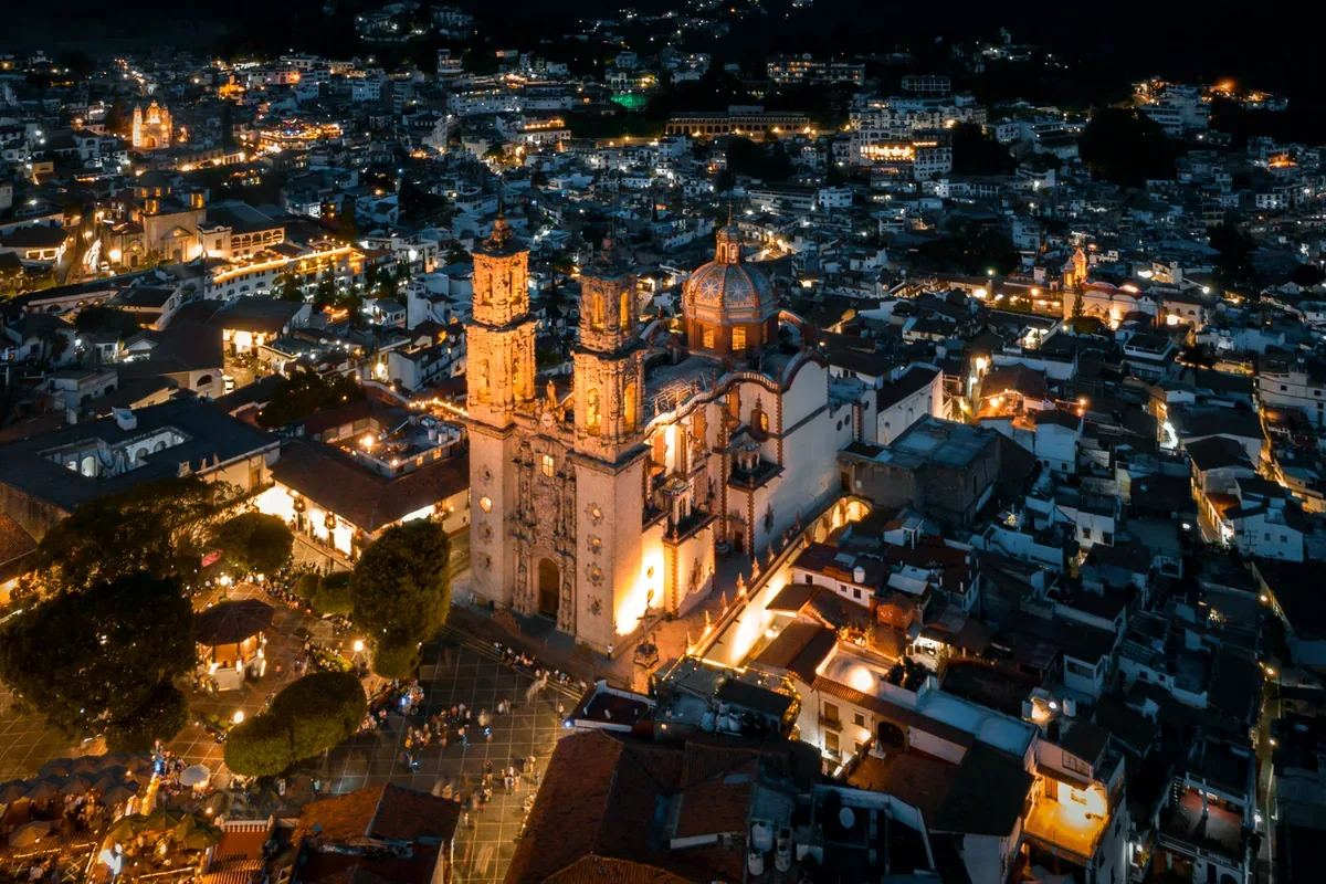 Taxco iluminado de noche con la iglesia de Santa Prisca al centro