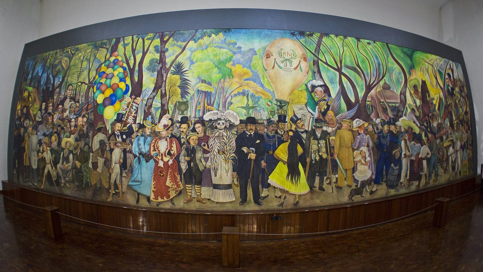 Mural de Diego Rivera con decenas de personajes en un parque, entre ellos una figura esquelética con sombrero de plumas al centro