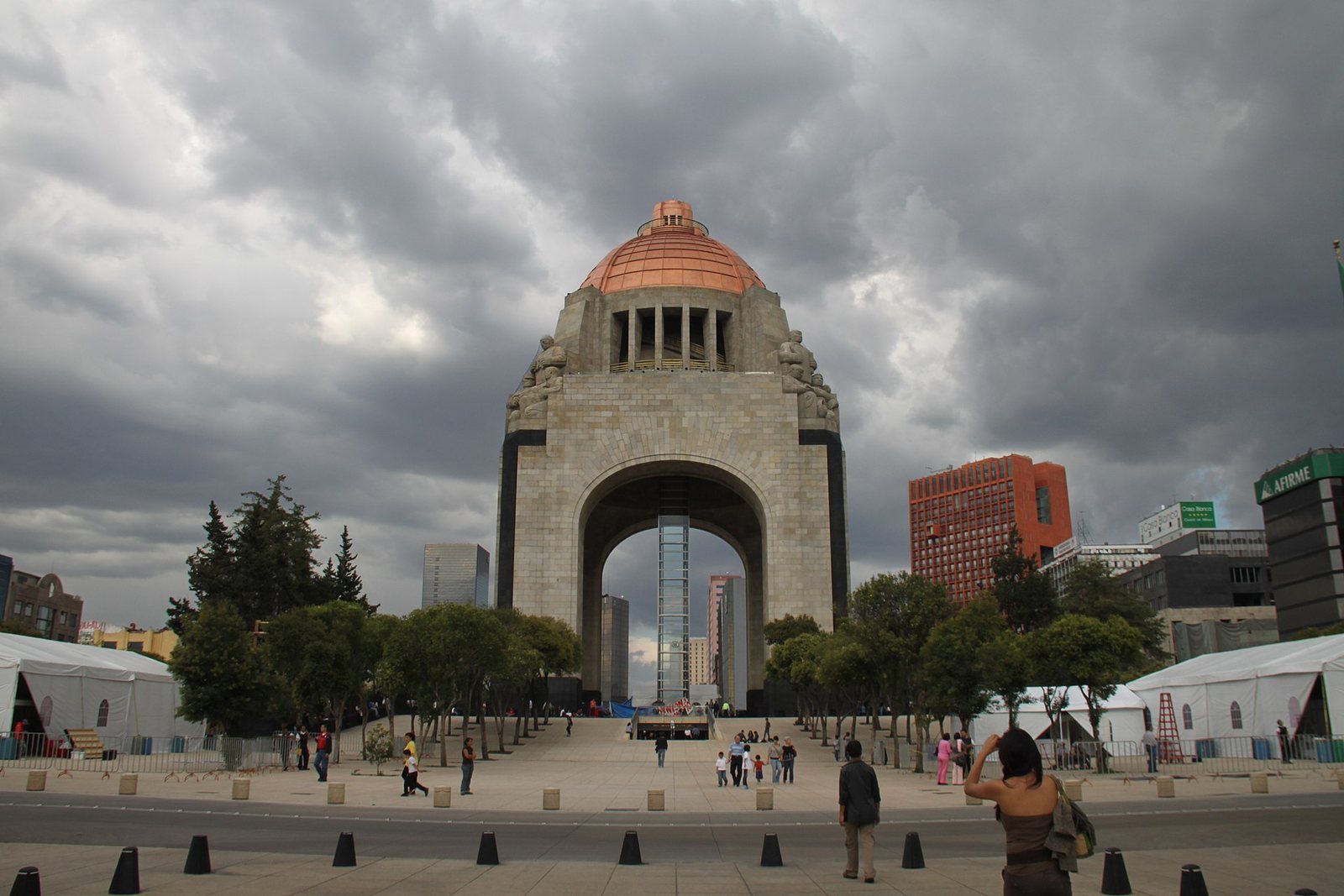 Monumento a la Revolución en la Ciudad de México bajo un cielo nublado, con paseantes en la explanada