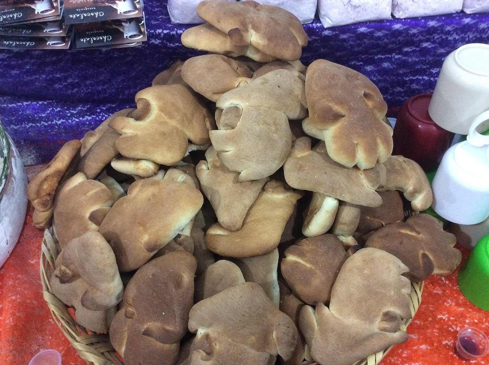 Montón de panes de forma alargada y dorada en una canasta de mimbre, en un puesto de Coyoacán