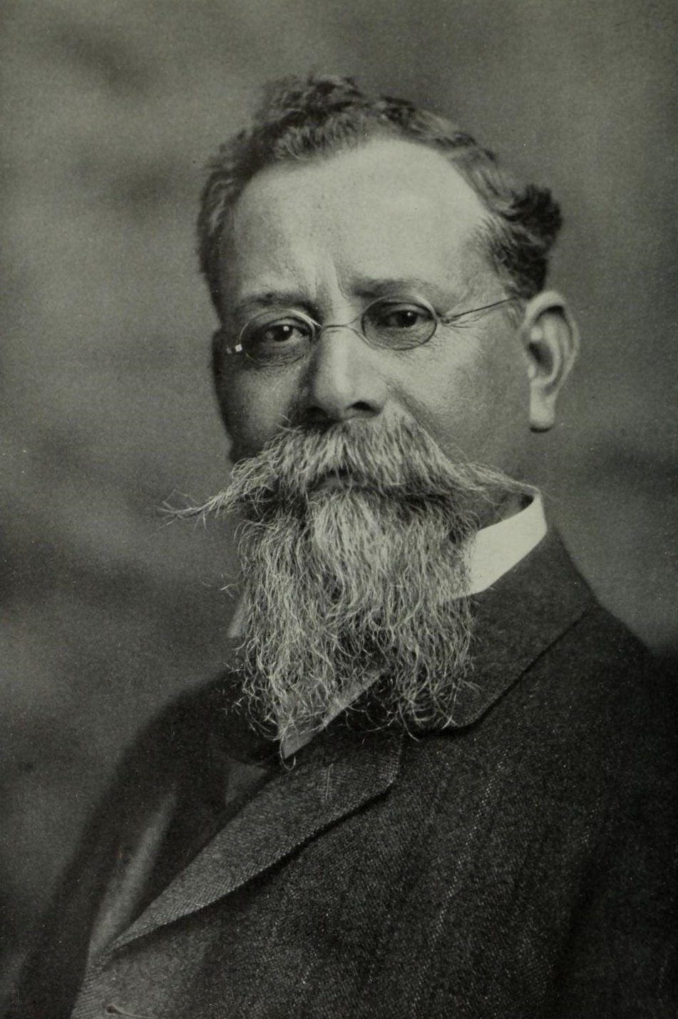 Retrato en blanco y negro de Venustiano Carranza, con lentes redondos, barba larga y bigote espeso