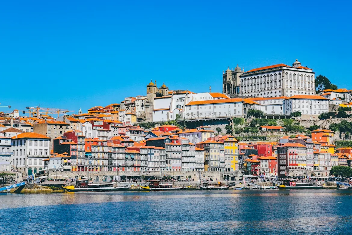Casas de colores del barrio de la Ribeira, en Oporto, frente al río Duero con barcos rabelos amarrados