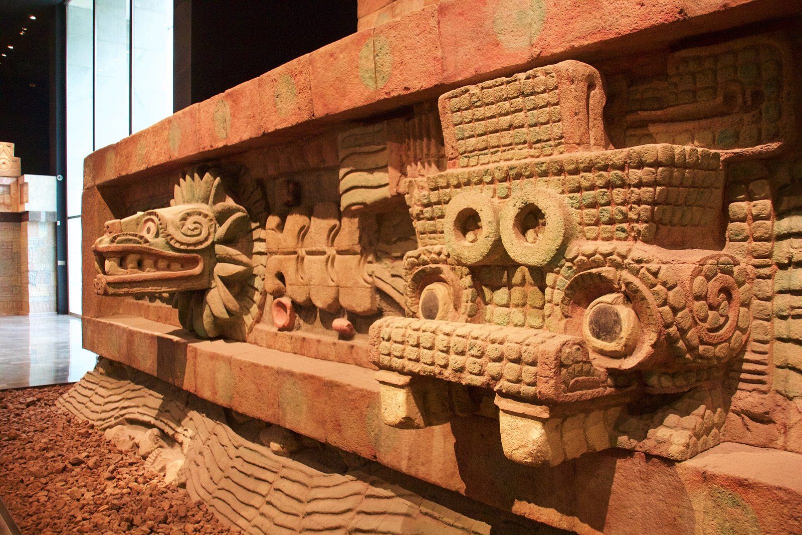 Fachada de la réplica del Templo de Quetzalcóatl en el Museo Nacional de Antropología, con cabezas de serpiente emplumada y relieves en rojo y verde